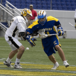 a couple of men playing a game of lacrosse.