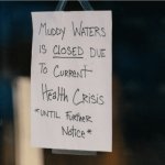 a sign hanging on a door that says muddy waters is closed due to current health.
