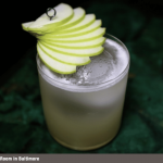 a drink with an apple slice on top of it.