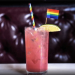 a drink with a rainbow flag sticking out of it.