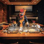 a man in a restaurant with a fire mask on.