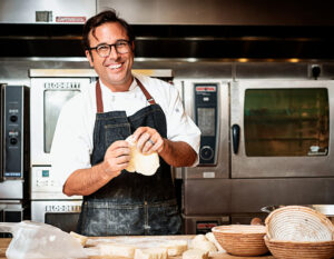 a man is making a sandwich in a kitchen.