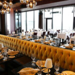 a restaurant with a long yellow banquet table.