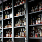 a wall full of liquor bottles in a bar.