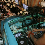 a dj mixing in front of a crowd of people.