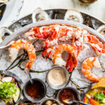 a platter of seafood and oysters on ice.