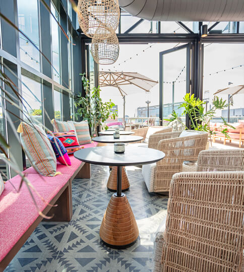 a restaurant with tables, chairs, and umbrellas.