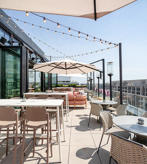 a patio with tables, chairs and umbrellas.
