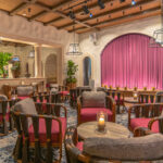 a restaurant filled with lots of tables and chairs.