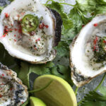 a plate of oysters with a lime wedge.