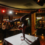 a woman doing a handstand on top of a table.