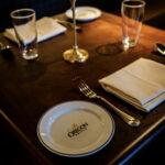 a table set with a plate, silverware, and napkins.