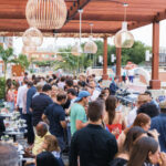 a large group of people standing around a food court.