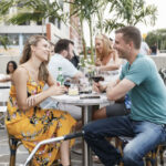 a group of people sitting at a table with wine glasses.