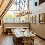 a dining room with a large table and a clock on the wall.