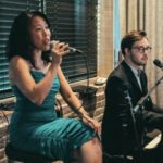 a man and a woman sitting in front of microphones.