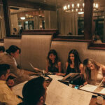 a group of people sitting at a table in a restaurant.