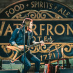 a man playing a guitar on a stage.