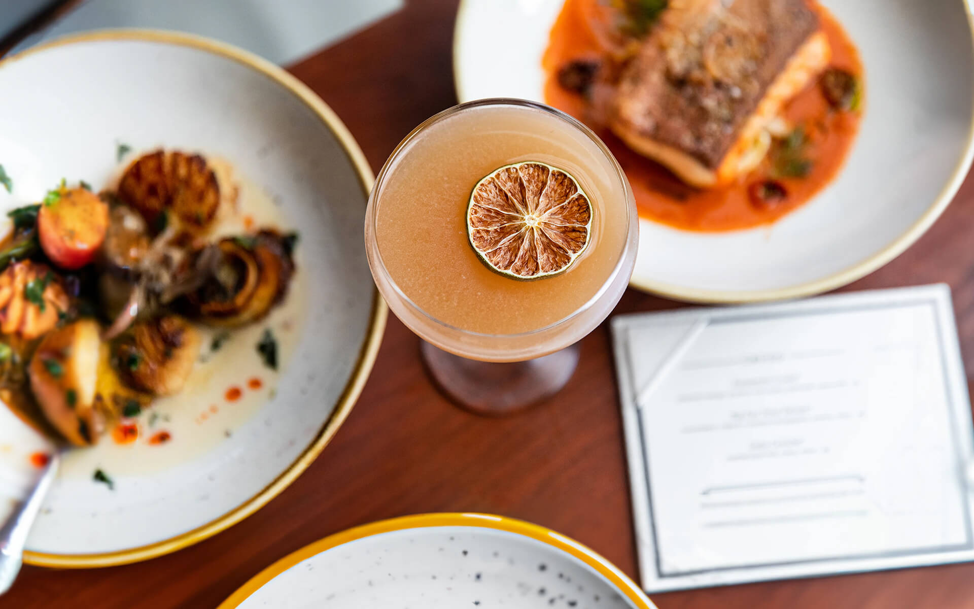 a table topped with plates of food and a drink.